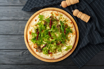 Fresh tasty pizza on black wooden background