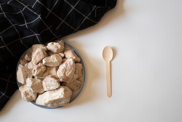 White clay stones with a wooden fork on a white background