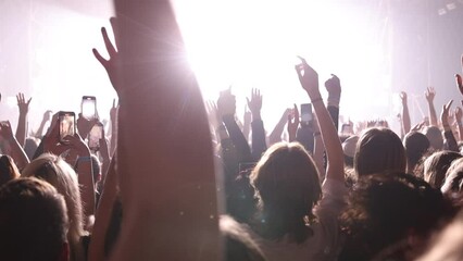 Cheering people crowd on the dance floor during a music concert