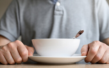 Awaiting Culinary Delight: white soup plate and man's hands