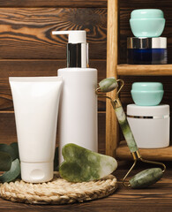 Tubes with cream on the background of a brown tabletop in the bathroom. Shelf with cosmetics. Face and body skin care. Moisturizer, toner and serum. Beauty concept. Place for text. Copy space.