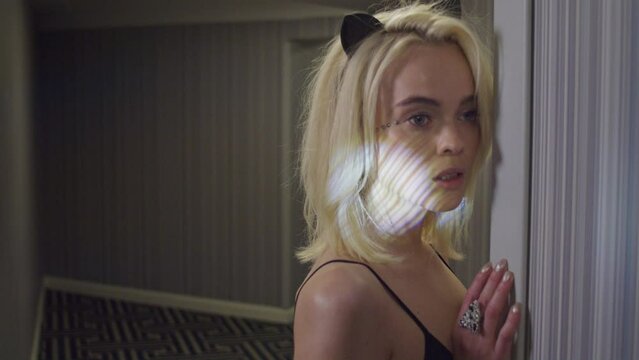 Portrait of a woman in animal ears and lingerie in a modern hotel hallway with abstract light hitting face