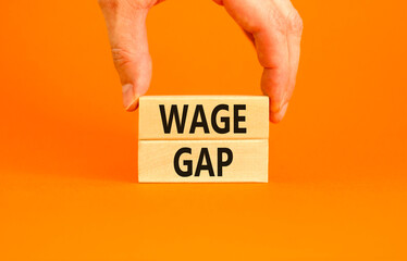 Wage gap symbol. Concept words Wage gap on wooden blocks on a beautiful orange table orange background. Businessman hand. Business, support and wage gap concept. Copy space.