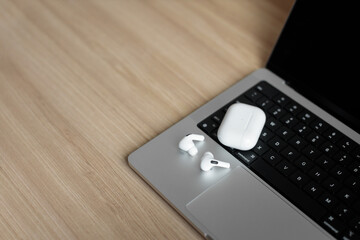 white wireless headphones on a laptop.
