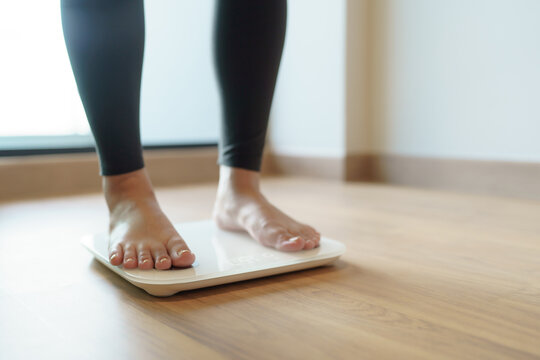 Lose Weight. Fat Diet And Scale Feet Standing On Electronic Scales For Weight Control. Measurement Instrument In Kilogram For Diet.