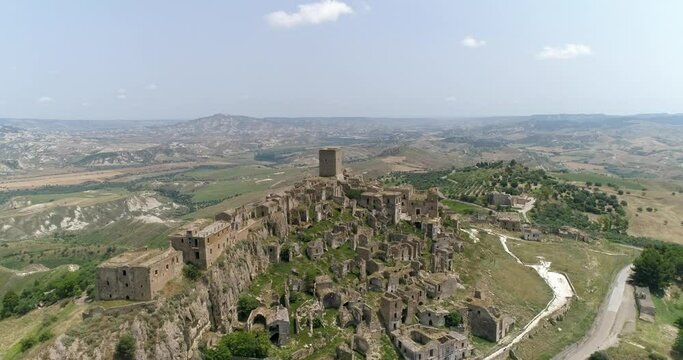 Aerial drone view in Craco, Italy. Small town built on a clay hill. Ghost town causes landslides and earthquake. An isolated ghost town set famous for horror films and dramatic sceneries.