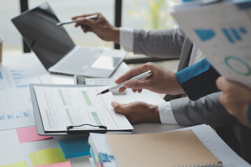 Financial analysts analyze business financial reports on a digital tablet planning investment...