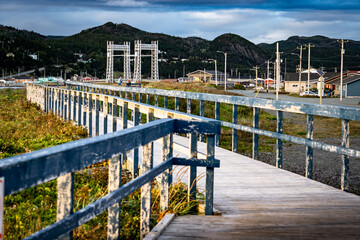 Beachfront wooden boardwalk with railing overlooking the Shae Lift Bridge along the East Coast of Canada in Placentia Newfoundland.