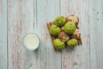 top view of sweet cookies and glass of milk on wooden table 