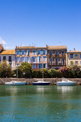 Naklejka premium Façades le long du Quai Commandant Réveille à Agde donnant sur le fleuve Hérault et ses petits voiliers amarrés