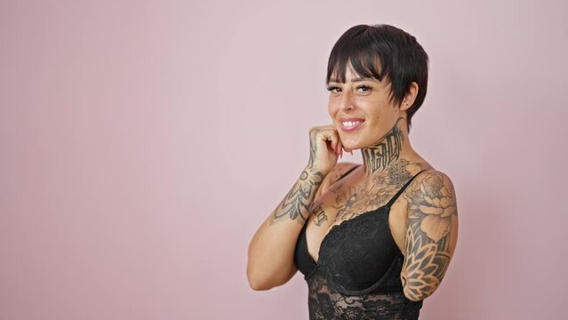 Hispanic woman with amputee arm wearing lingerie smiling over isolated pink background