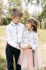 Two children, dressed festively, present wedding rings for brides
