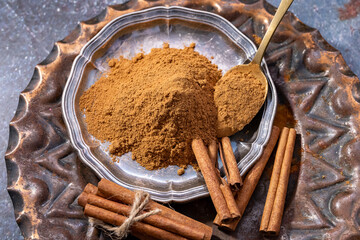 Cinnamon stick and cinnamon powder placed on the metal plate.viewed from above, isolated