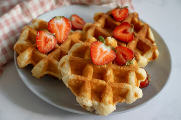 Waffles with strawberries on a light background