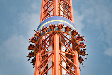 People free falling from tower ride at amusement park. Famous attraction Free Fall Tower in the amusement park
