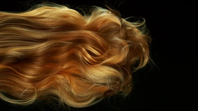 Super slow motion of wavy red hair in detail. Filmed on high speed cinema camera, 1000 fps. Isolated on black background.