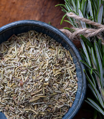 Dried and ground rosemary placed in a ceramic bowl viewed from above