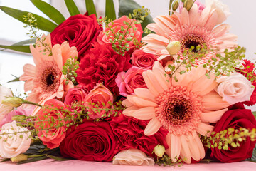 Closeup Beautiful Fresh Bouquet Of Flowers For Bride Or Occasion On Table. Colorful Mixed Roses, Carnation Shabot, Green Leaves, Gerber. Horizontal Plane