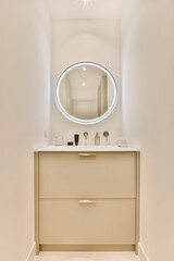 a bathroom with a round mirror on the wall above it and a white toilet in the sink is next to the...