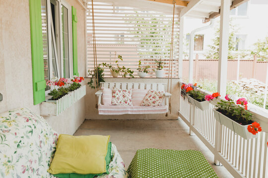 hanging swing in a rustic style on the terrace of a country house.