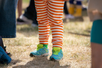 Orange striped stockings and blue sneakers on the child