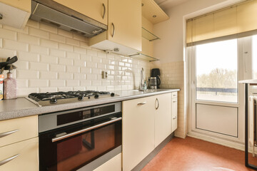 a kitchen with an oven and dishwasher on the counter top in front of the sink is white tiles