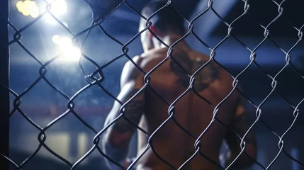 Fotobehang Close-up shot of MMA boxing athlete in the ring with cage © didiksaputra
