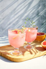 Summer chilled cocktails with citrus fruits. Drink with grapefruit or red orange and a sprig of thyme.