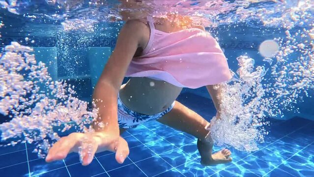 little girl swims with glasses in the pool