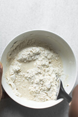 Partially mixed bread dough, flour being folded into water, process of making focaccia