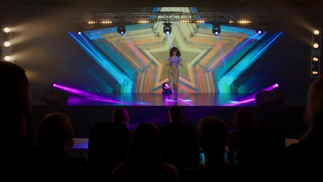 Young female woman girl dancer is performing her dance during talent show auditions. Recording of television style broadcast talent show