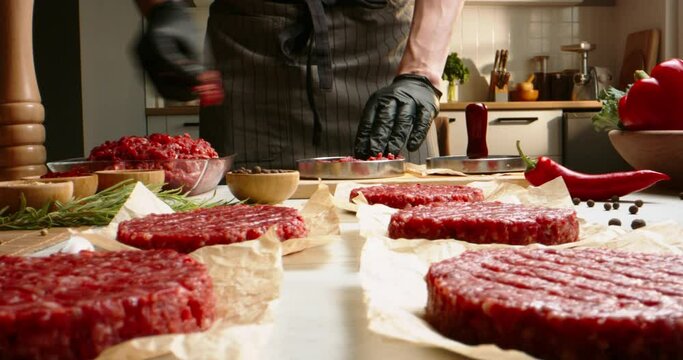 Chef prepares blanks for hamburgers from fresh minced meat in a kitchen with subdued lighting, Professional promotional video Advertising. Cooking minced meat for burger in bright kitchen. Cook food