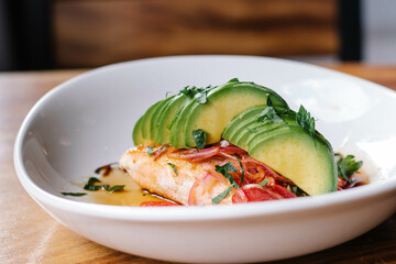 Salmón sobre cama de miel con jitomate y aguacate 