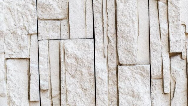 Wall, masonry of flat stones beige uneven, rotating, turning, close-up, looped video
