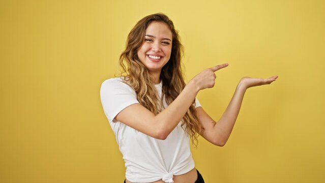 Young beautiful hispanic woman smiling pointing to the side presenting over isolated yellow background