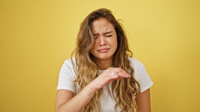 Young beautiful hispanic woman sneezing over isolated yellow background