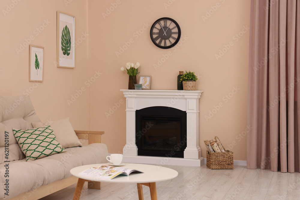 Wall mural Stylish fireplace near comfortable sofa and coffee table in cosy living room