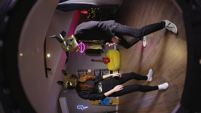Two dancers record trending reels for social media channel. In halloween masks unknown unrecognizable. Vertical video bull and wolf masks. Blogger shoot popular dance video on TikTok to trending