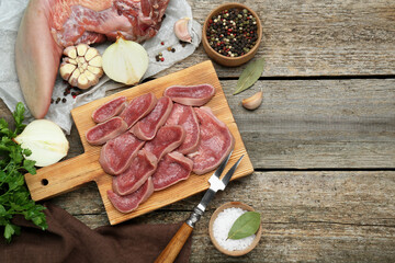 Board with slices of raw beef tongue and products on wooden table, flat lay. Space for text - obrazy, fototapety, plakaty