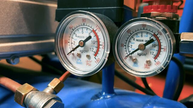 Analog gauges installed on a new gasoline-powered electricity generator in a hardware store. Close-up shot