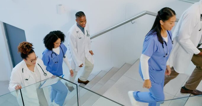 Team of doctors walking up the stairs in the hospital while in discussion on a diagnosis. Collaboration, teamwork and group of professional medical workers talking about research in a medicare clinic