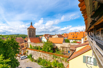 Obraz premium View from the medieval fortified wall of the half timber village homes and the Weisser Turm tower in the Bavarian city of Rothenburg ob der Tauber, Germany.