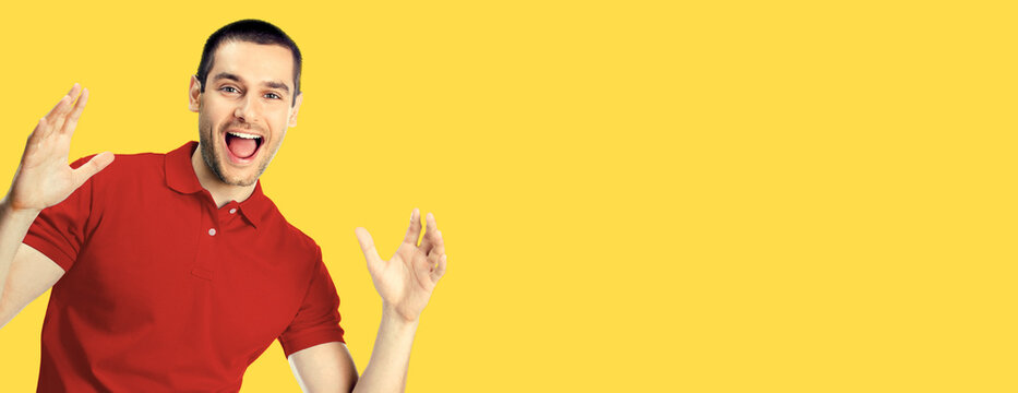 Unbelievable good news! Very happy man, isolated over yellow color background. Emotions and success concept. Excited male model gesturing with open mouth, saying wow, red casual clothing, studio image