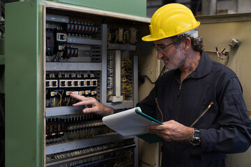 Senior male electrician worker checking, repair, maintenance electric system of CNC machine in...