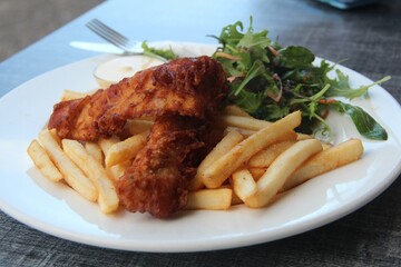Delicious fish and chips served with vegetables on a plate.