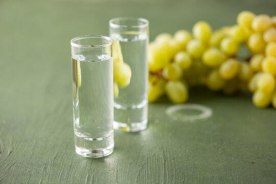Traditional Georgian  chacha, also known as grape vodka or Georgian grappa in shot glasses  and fresh grapes