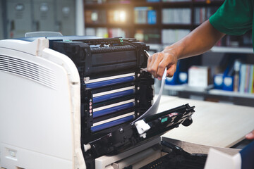 Technician hand open cover photocopier or photocopy to fix repair copier paper jam and replace ink cartridges for scanning fax or copy document in office workplace.