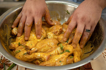 a man mixing a chicken with a spices