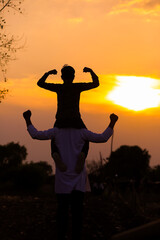 Fototapeta premium Father carrying son on shoulders on field against sky
