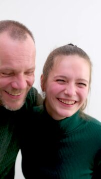man and girl leaned over and stuck out tongues in background light for video photography father and daughter teacher student husband wife green sweaters 